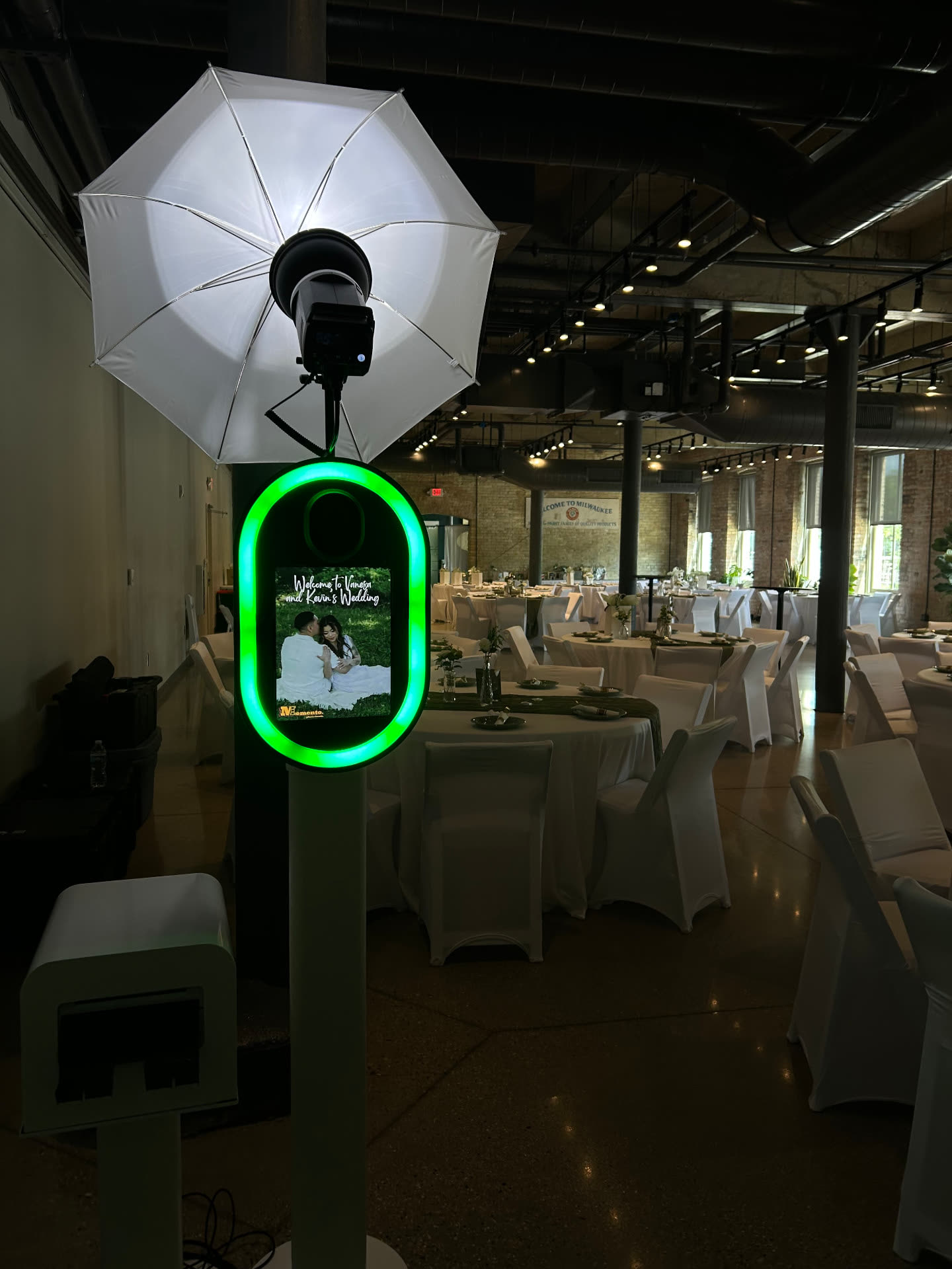 Memento photo booth with glowing green ring light and umbrella flash set up at a Milwaukee wedding reception