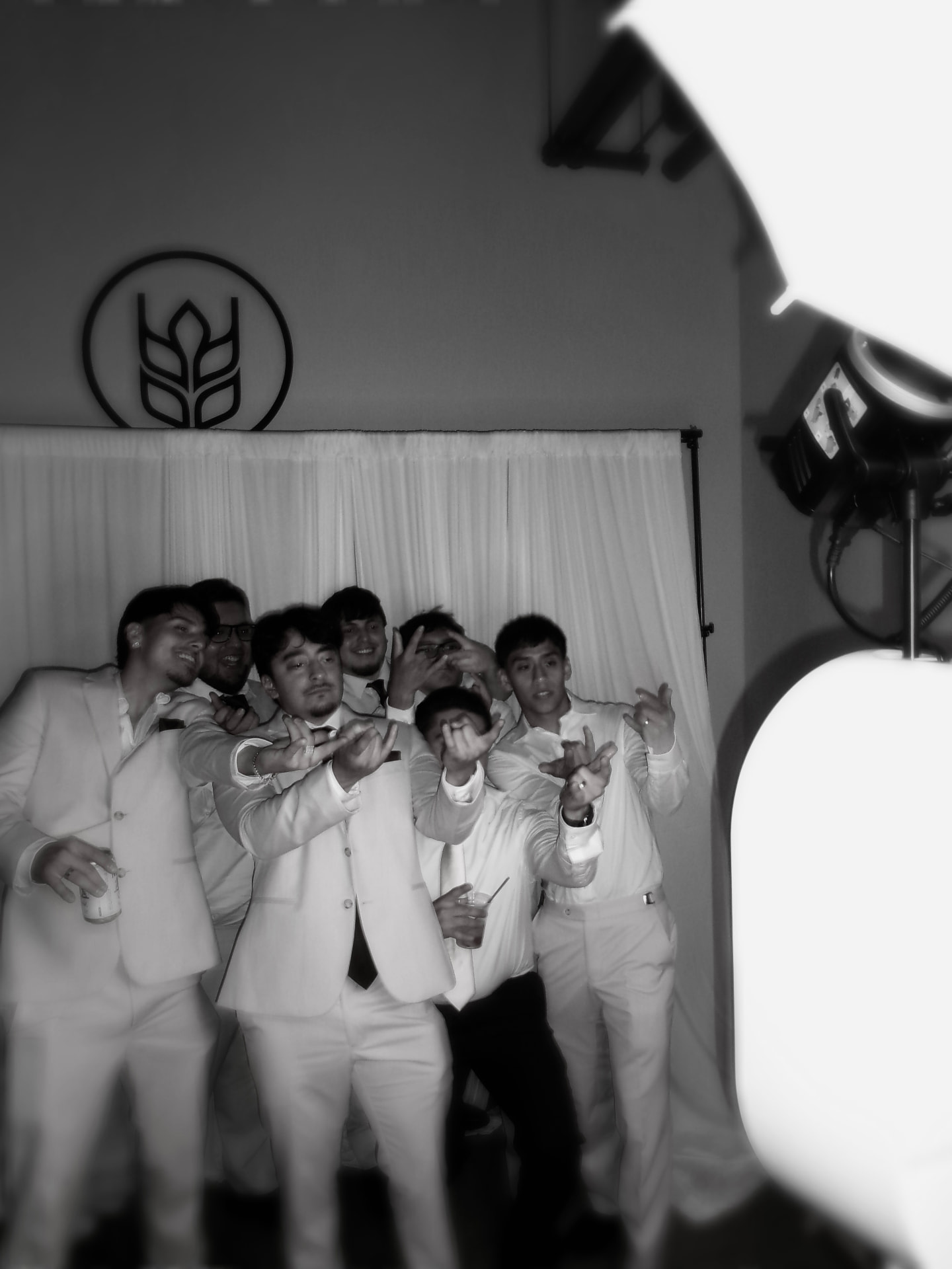 Groomsmen in cream suits having fun in the Memento photo booth