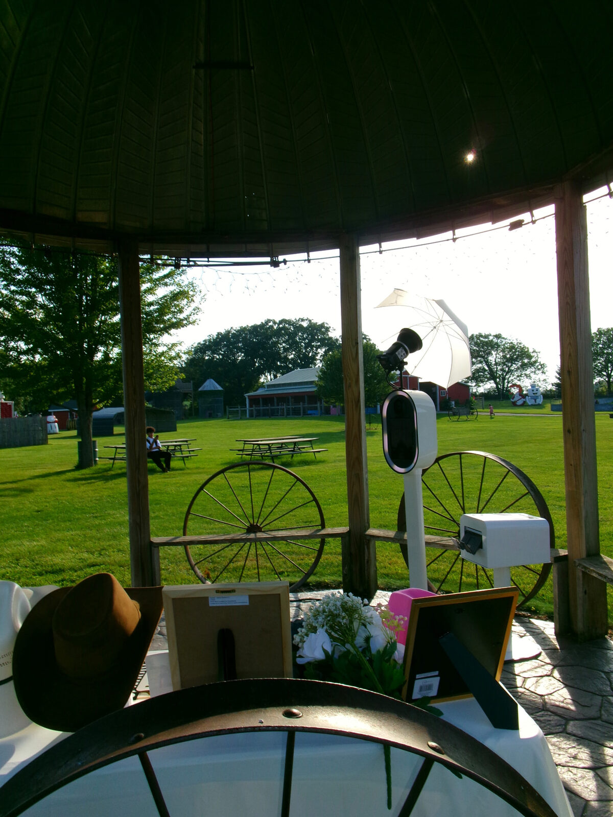 Memento photo booth with umbrella flash set up in a gazebo at a countryside barn venue