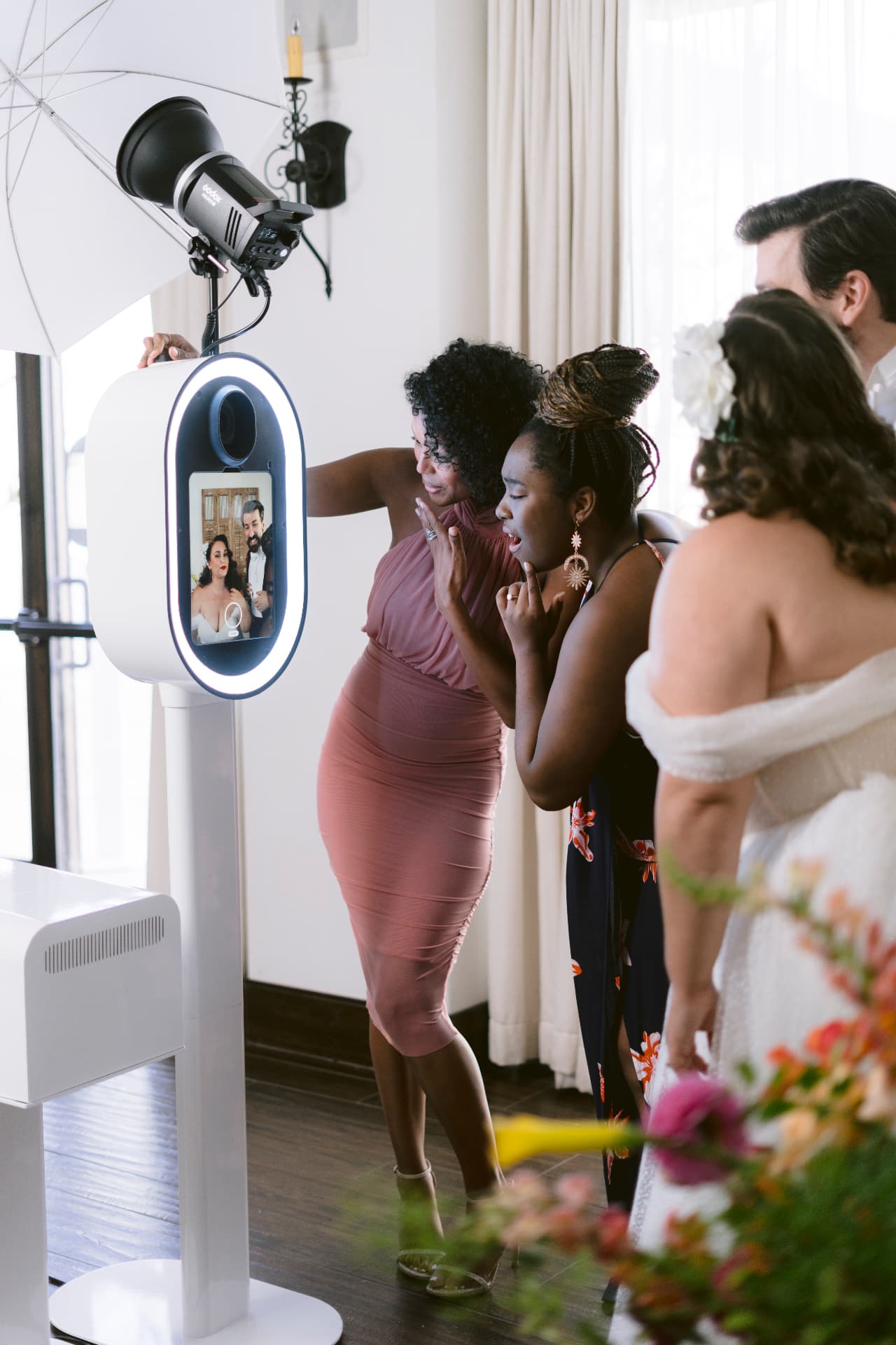 Wedding guests laughing in front of the photo booth